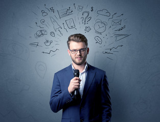 Businessman speaking into microphone with mixed doodles over his head