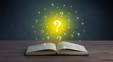 Yellow question marks hovering over open book 