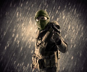 Close up of an armed terrorist man with mask on rainy background