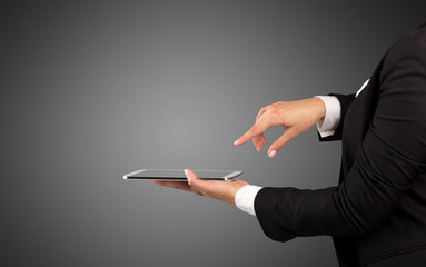 Female hand in suit holding tablet with no wallpaper
