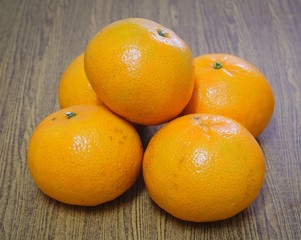 Five Ripe Oranges on A Wooden Table