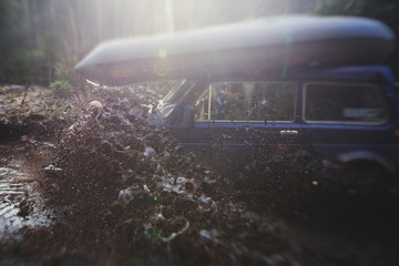 Suv offroad 4wd car rides through muddy puddle, off-road track road, with a big splash, during a jeeping competition