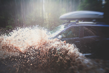 Suv offroad 4wd car rides through muddy puddle, off-road track road, with a big splash, during a jeeping competition © tsuguliev