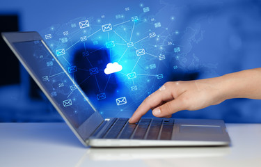 Hand using laptop with cloud computing and online storage concept
