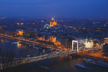 Beautuful super-wide angle aerial night view of Budapest, Hungary, with Danube river, Parliament building and scenery beyond the city, seen from observation point of Gellert Hill