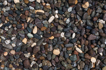 Textured background from dark smooth sea pebbles