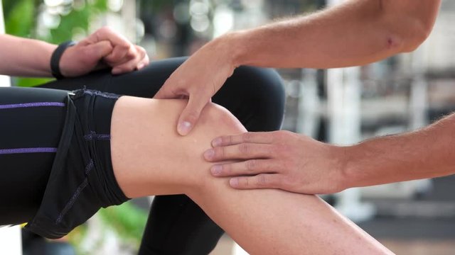 Male hands massaging female knee. Girl with pain in knee joint sport workout. Sport accident concept.