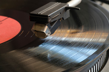 Vinyl analog record player's stylus is in contact with the surface LP. Close up.