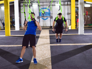 men working out pull ups with gymnastic rings