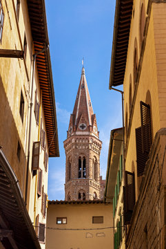 Bell tower of church Badia Fiorentina in Fraternity of Jerusalem abbey. View from old street in Florence city, Italy