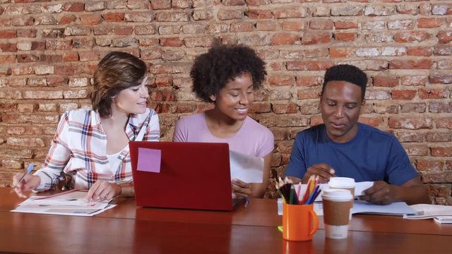 Small team of young professionals working at a table