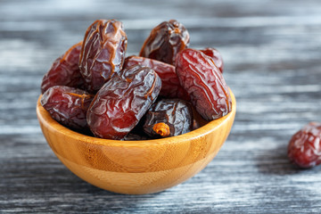 Dried fruits of date palm in a wooden bowl.