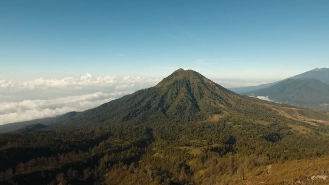 Mountain landscape, clouds, relief. Aerial view of Green tropical mountain cover with cloud Banyuwangi Regency of East Java, Indonesia. 4K Aerial footage.
