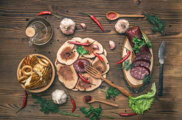 Sausage snag, pita bread, bagels, tomatoes, garlic, chilli pepper and greenery with fennels, dill and parsley on wooden table background.