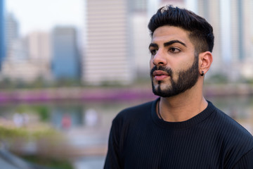 Obraz premium Young handsome Indian man thinking while looking at distance aga