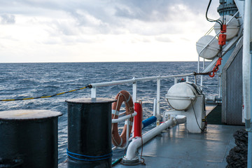 View of ocean from ship or vessel. LSA life saving equipment is on deck - liferafts , orange lifebouy ready for use in case of emergency