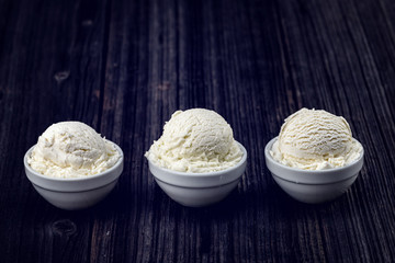 Vanilla ice cream with bowl on wooden background