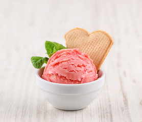 strawberry ice cream with bowl on wooden background