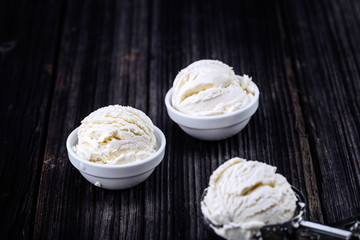 Vanilla ice cream with bowl on wooden background