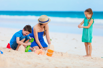 Fototapeta na wymiar Mother and kids playing at beach