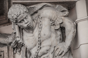 Fototapeta premium Statue of powerful Egyptian slave supporting balcony in downtown of Prague, Czech Republic