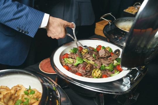Catering buffet food indoor in luxury restaurant with meat colorful fruits and vegetables. People at a banquet taking different food. Colleagues Buffet Party Brunch Dinning Concept