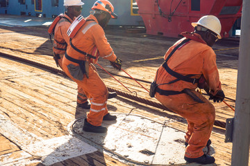 Anchor-handling Tug Supply AHTS vessel crew preparing vessel for static tow tanker lifting. Ocean...
