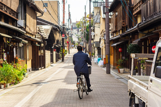 Fototapeta Cyclist on a city street in Kyoto, Japan. Copy space for text.