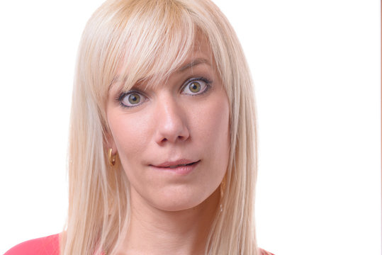 Quizzical blond woman biting her lip