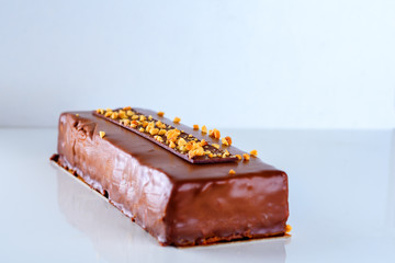 Chocolate cake decorated with nuts on white background.