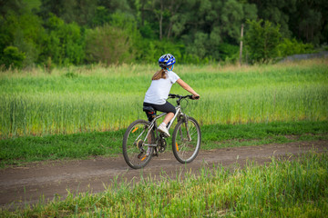 Fototapeta premium Girl ride on bike on rural landscape