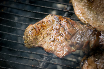 Barbecue lunch. Grilled meat chops in a black cast iron pan, close-up