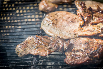 Barbecue lunch. Grilled meat chops in a black cast iron pan, close-up
