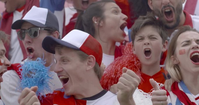 British football fans cheering at football match, slow motion