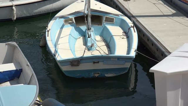 A small boat reflecting in the water at the pier
