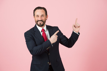 Manager pointing up by fingers on pink background. Man in suit advertise place by hands. Officer points to space for advert