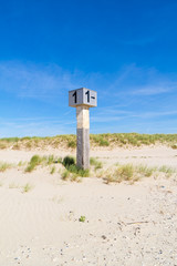 Beach post on sand against blue sky, IJmuiden, Netherlands