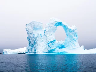 Meubelstickers Boogvormige ijsberg op het ijsbergkerkhof van Pleneau Bay ten westen van het Antarctisch Schiereiland, Antarctica © TasfotoNL