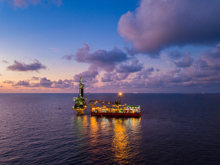 Obraz premium Aerial View of Tender Drilling Oil Rig (Barge Oil Rig) in The Middle of The Ocean at Sunset Time