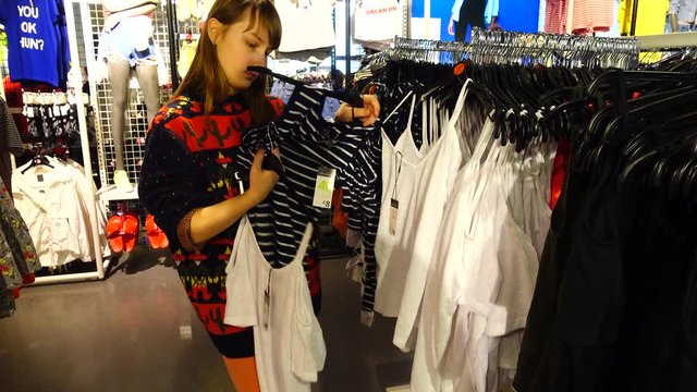 Shopping in outlets Europe. The girl chooses clothes.	Sale and discounts.