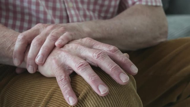 Close Up Of Man Suffering With Parkinsons Disease Holding Trembling Hand