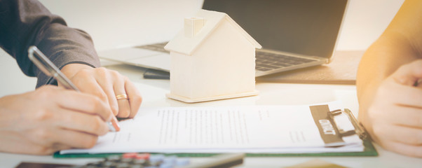 Client Signs Document to Buy House and Real Estate