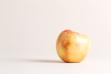 A ripe red apple on a cream background