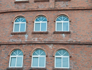 Loft red bricks industrial wall and windows of an old factory