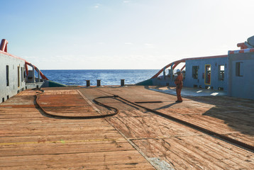 Anchor-handling Tug Supply AHTS vessel crew preparing vessel towing wire for static tow tanker...