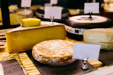 Cut many kind of cheese wheels for sell. 
