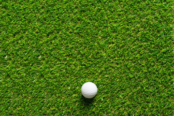 Golf ball on green grass texture of golf course for background.