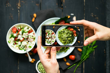 Phone photography of food. Woman hands take photo of lunch with smartphone for social media. Raw...