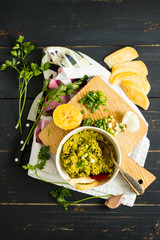 Avocado dip sauce with olive oil, garilic, spices and greens. Raw, vegan, vegetarian healthy food concept.