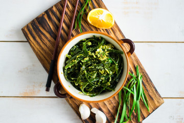 Japanese asian chuka laminaria seaweed salad with dressing of onion, garlic, lemon, sesame seeds and oil. Traditional lunch or dinner. Used to eat with chopsticks. Raw, vegan, vegetarian healthy food
